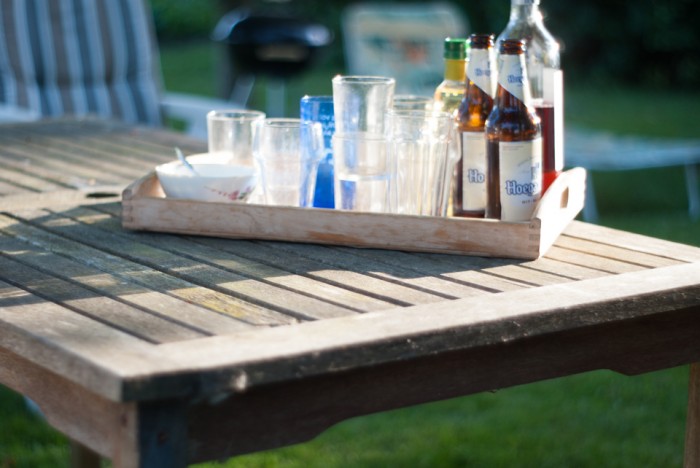 Tuintafel met een dienblad met glazen en flessen