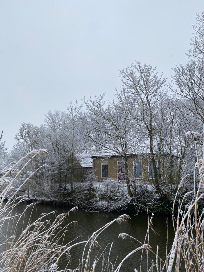 Het huis aan het water in de sneeuw